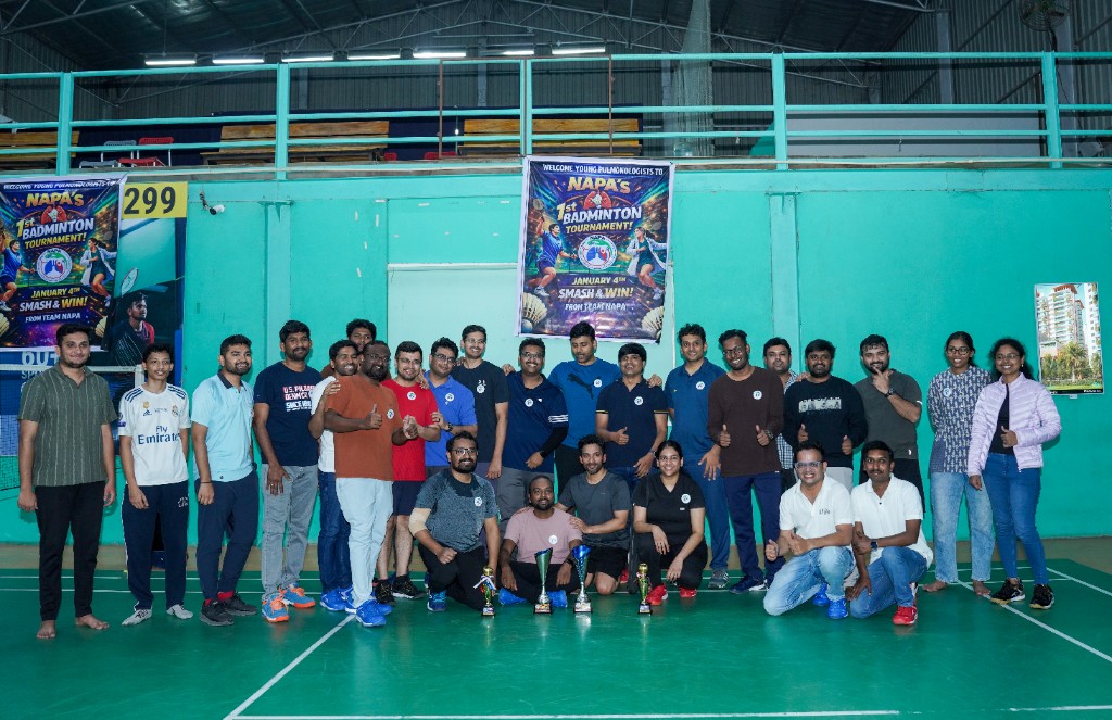 Group photograph at the first NAPA badminton tournament with trophies