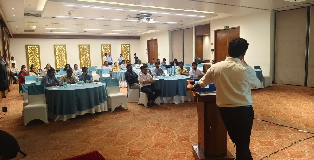 Presenter speaking to participants seated at round tables