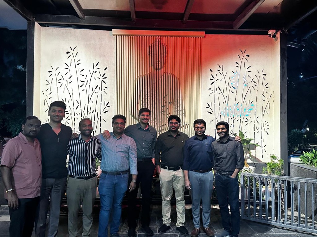 Evening group photograph at a dinner venue with warm lighting